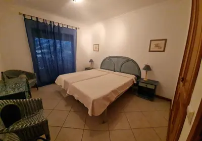 a bedroom with a bed and a chair and a window at Jardins Santa Eulalia by Garvetur in Albufeira