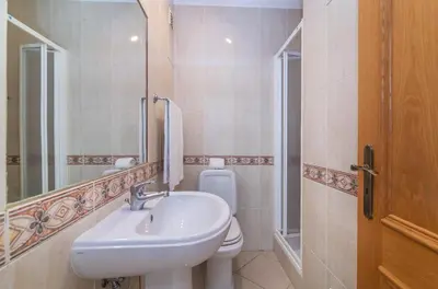 a bathroom with a sink and a toilet and a mirror at Jardins Santa Eulalia by Garvetur in Albufeira
