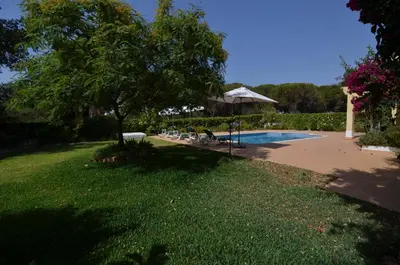 a yard with a swimming pool and a tree at Bonita in Quarteira