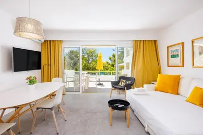 a living room with a white couch and a table at Quinta Do Romão in Vilamoura