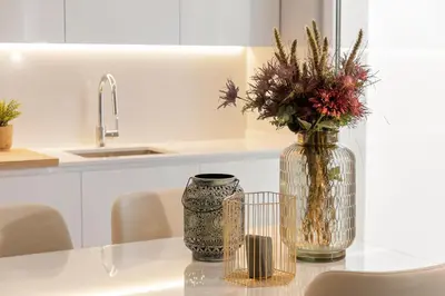 a vase with flowers on a table in a kitchen at Vila Balaia - Luxury Boutique Villas in Albufeira