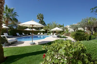 a swimming pool with umbrellas and chairs at Vila Balaia - Luxury Boutique Villas in Albufeira