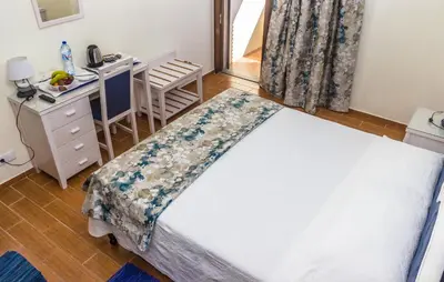 a bedroom with a bed and a table and a desk at Aeromar Beach Hotel in Faro