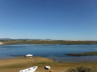 a group of boats sitting on the shore of a lake at Aeromar Beach Hotel in Faro