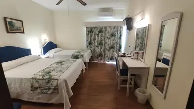 a hotel room with two beds and a desk at Aeromar Beach Hotel in Faro