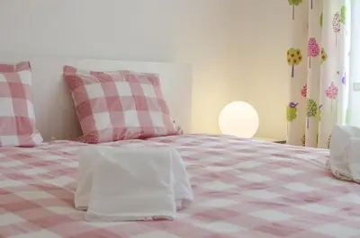 a bedroom with a pink and white checkered bed at Apartamento Solar in Quarteira