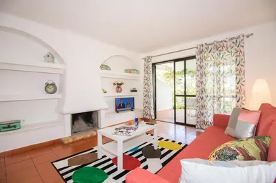 two chairs and a yellow umbrella in a yard at Apartamento Solar in Quarteira
