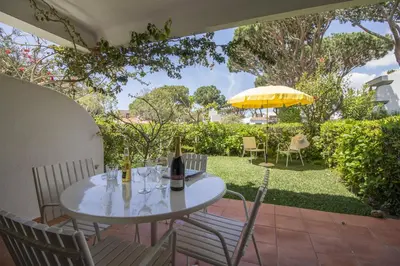 a dining room with a white table and chairs at Apartamento Solar in Quarteira