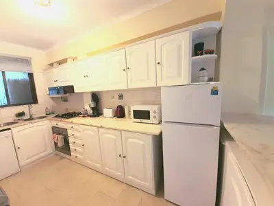 a kitchen with white cabinets and a white refrigerator at Apartment Amalia in Albufeira