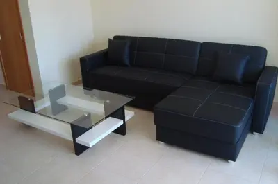 a living room with a black couch and a glass table at Vila Branca in Mosqueira