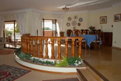 a living room with a staircase and a dining room at Genies Villa Boutique Algarve in Almancil