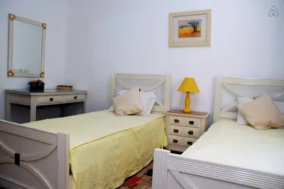 a bedroom with two beds and a table and a mirror at Genies Villa Boutique Algarve in Almancil