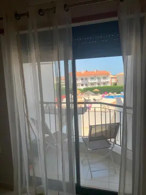 a balcony with a chair and a view of a pool at Vista das Ondas - AP in Albufeira