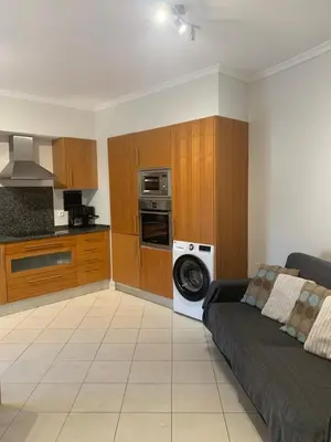 a living room with a couch and a kitchen at Vista das Ondas - AP in Albufeira