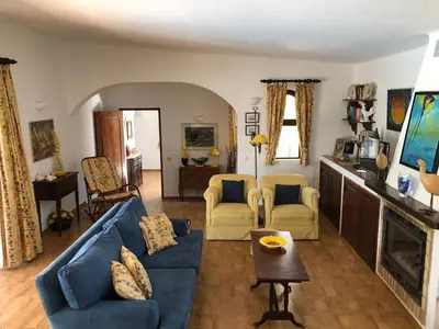a living room with a blue couch and chairs at Casa Camelia in Vilamoura