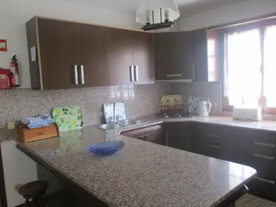 a kitchen with a granite counter top and a sink at Vivendas Costa in Barros da Fonte Santa