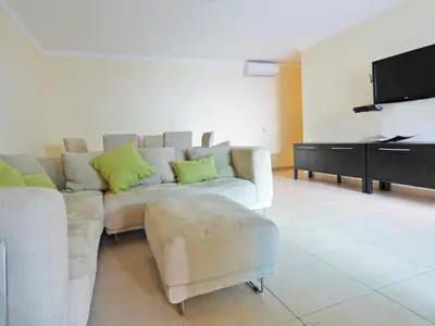 a living room with a couch and a flat screen tv at Apartamento Olhos D'Água in Albufeira