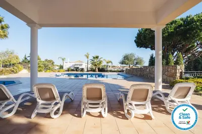 a patio with chairs and a swimming pool at Quinta do Lago - Apartamento Salinas in Quinta do Lago