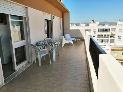 a balcony with tables and chairs on a building at Apartamento Penha T3 in Faro