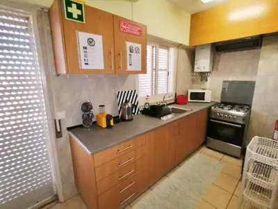 a kitchen with wooden cabinets and a sink and a stove at Apartamento Penha T3 in Faro