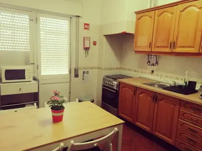 a kitchen with wooden cabinets and a wooden counter top at Apartamento S. Luis in Faro