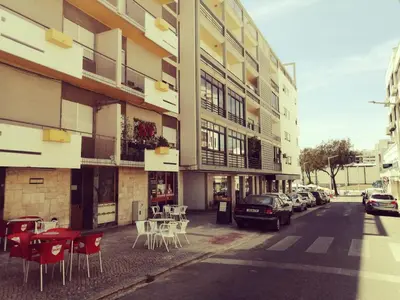 a street with chairs and tables and a building at Apartamento S. Luis in Faro