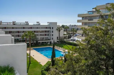an apartment with a swimming pool in front of a building at Marina Vilamoura Relax in Vilamoura