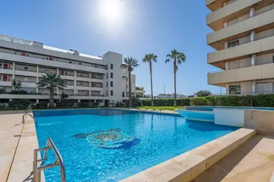 a swimming pool in front of a building at Marina Vilamoura Relax in Vilamoura