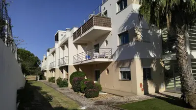 an apartment building with a balcony on the side of it at Olhos de Água Apartment Albufeira in Albufeira