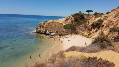 a group of people on a beach near the ocean at Olhos de Água Apartment Albufeira in Albufeira
