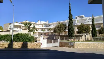a large white building with trees in front of it at Olhos de Água Apartment Albufeira in Albufeira