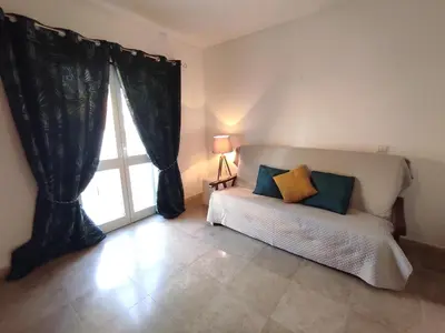 a living room with a couch and a window at Vila Magna near The Strip with BBQ, AC, Balcony, Parking, 4 TVs and Free wifi in Albufeira