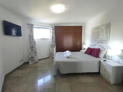 a bedroom with a white bed with two stuffed animals on it at Vila Magna near The Strip with BBQ, AC, Balcony, Parking, 4 TVs and Free wifi in Albufeira