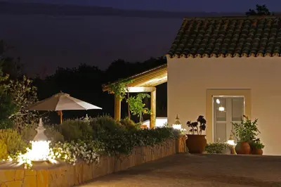 a house with an umbrella and a garden at night at Retiro da Janela in Boliqueime