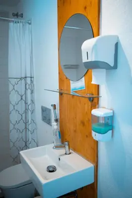 a bathroom with a sink and a mirror and a toilet at Wax Hostel in Faro