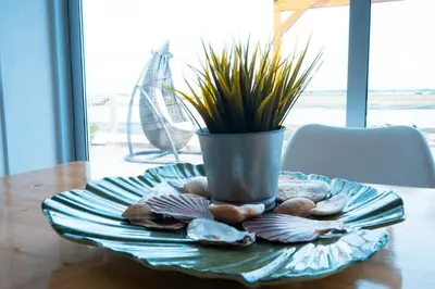 a plate with a vase on a table with shells at Wax Hostel in Faro