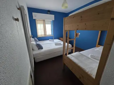 a room with two bunk beds and a window at Wax Hostel in Faro