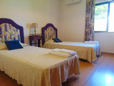 a bedroom with two beds and a window at Vila Ninita in Vilamoura