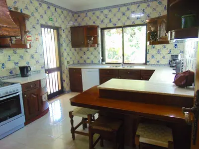 a kitchen with a wooden table in a room at Vila Ninita in Vilamoura