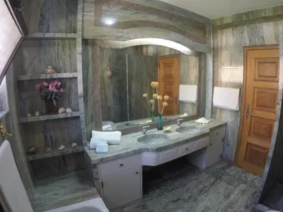 a bathroom with a sink and a large mirror at Vila Ninita in Vilamoura