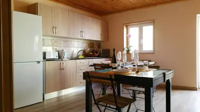 a kitchen with a table and a white refrigerator at Happy House in Faro