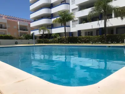 a resort with a swimming pool and a building at Timeless Vacations Vilamoura Marina Flat WIFI & Pool in Vilamoura