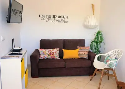 a living room with a brown couch and a chair at Golden Cliff House in Albufeira