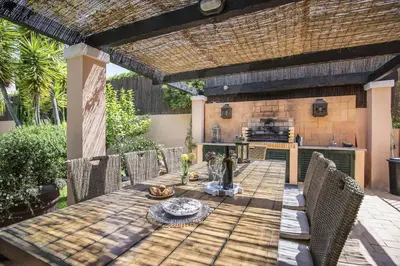 a patio with a table with chairs and a kitchen at Rubi in Vilamoura