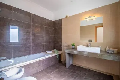 a bathroom with a tub and a toilet and a sink at Casa no Sol in Loulé