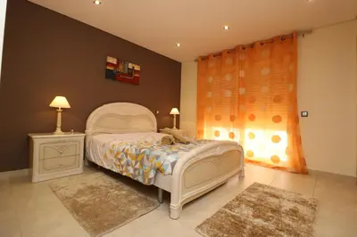 a bedroom with a white bed and a window at Alsol in Quarteira