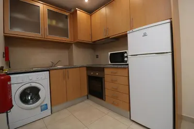 a kitchen with a white refrigerator and a dishwasher at Alsol in Quarteira