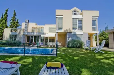 a patio with wicker chairs and a swimming pool at Villa Lake View in Quarteira