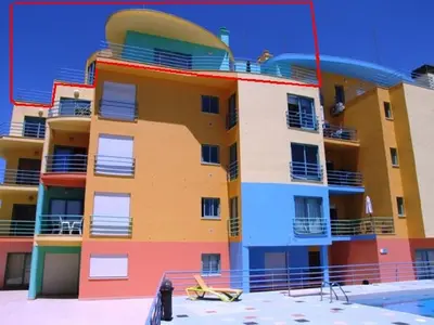 a colorful building with a pool in front of it at Penthouse Marina in Albufeira