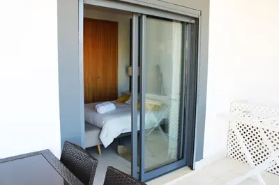 a balcony with sliding glass doors with a bed at Apartment with terrace Albufeira Olhos de Água in Albufeira